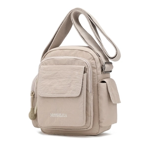 Detail of beige nylon crossbody bag showing durable pleated texture and functional pockets