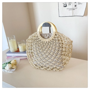 Close-up of bohemian woven tote bag with wooden ring handles and drawstring inner bag