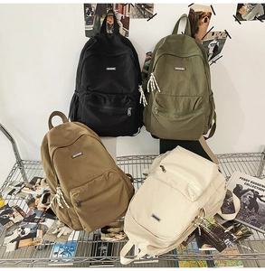 Close-up of durable canvas backpacks in four colors showing zipper and front pocket details