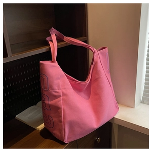 Detailaufnahme der rosa Canvas-Einkaufstasche mit breitem Gurt und blauem Buchstabenaufdruck