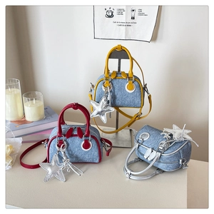 Detailed view of mini denim handbags in yellow, red and silver with star charms