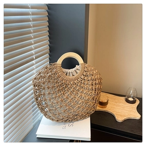 Detail of hand-woven hollow straw tote bag with round wooden handle and drawstring liner