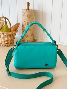 Versatile turquoise nylon crossbody pillow bag with ruched handles and multi-zipper pockets
