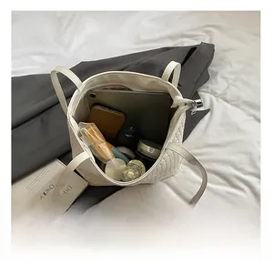 Interior view showing the large capacity of the white woven leather bucket bag