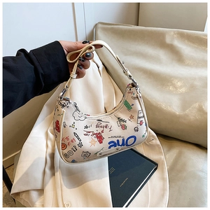Detailed close-up of crescent hobo bag with colorful graffiti and adjustable shoulder strap