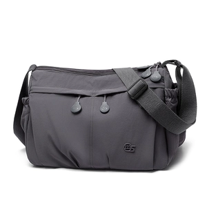 Detail of dark grey nylon crossbody bag showing multiple zip pockets and adjustable strap