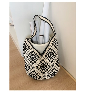 Detail showing hand-woven black and white floral patterns on a cotton tote bag