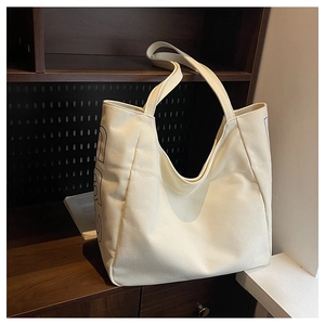 Detailed view of the large canvas tote bag with side blue letter print and sturdy seams