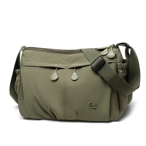 Macro shot of army green nylon crossbody bag with zipper pockets and logo detail
