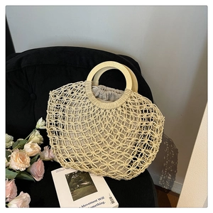 Detail of hollow woven bag featuring round wooden handles and drawstring inner pouch