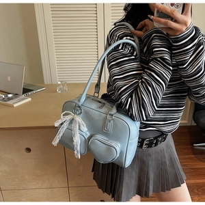 Detail of light blue PU shoulder bag with heart-shaped pocket and lace pearl bow charm