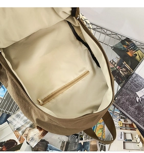 Top view of large brown canvas backpack interior showing the main storage and zipper pocket