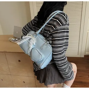 Detail of light blue patent leather tote bag with white lace bow and pearl charms
