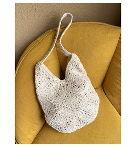Detail showing artisanal crochet pattern and cotton weave of the ivory tote bag