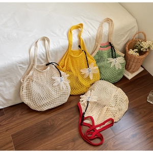 Detailed close-up of knitted mesh tote bags with floral charms in four vibrant colors