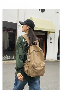 Street style view of a khaki nylon backpack with large capacity and zippered pockets