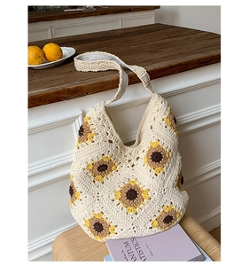 Detailed close-up of beige crochet sunflower tote bag with wide braided shoulder strap
