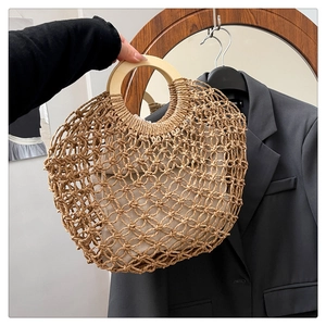 Close-up of handmade woven straw bag with round wooden handles and canvas lining