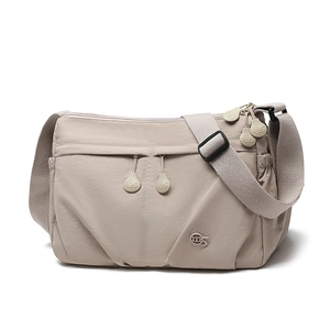 Detail of beige pleated nylon crossbody bag showing zipper compartments and ms logo