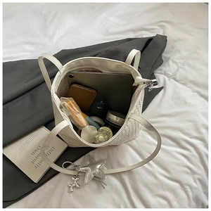 Top view of large white quilted tote bag showing spacious interior with tablet and items
