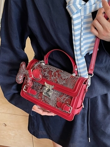 Red handbag with silver floral relief, puppy charm and adjustable strap for women