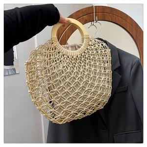Detail of hand-woven hollow mesh tote bag with smooth round wooden handles and drawstring inner