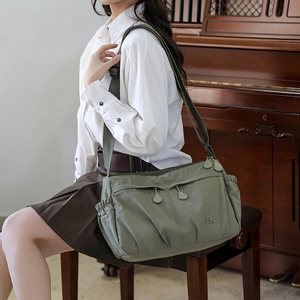 Detail of army green nylon crossbody bag with multi-pocket structure and wide strap