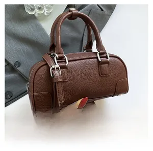 Détail du sac Boston marron vintage en cuir grainé avec poignées et boucles en métal