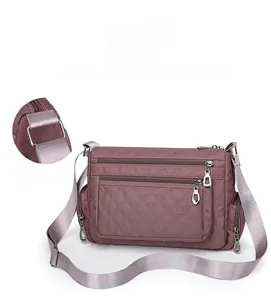 Detail showing high-quality silver hardware and shoulder strap connection on the purple nylon bag