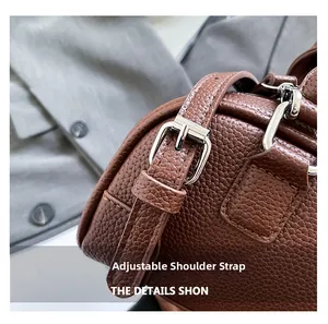 Détail du sac baguette en cuir grainé marron avec boucle en métal argenté réglable