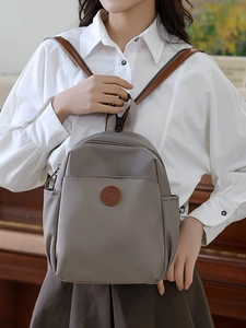 Chic taupe travel backpack with front zipper pocket and side water bottle holders