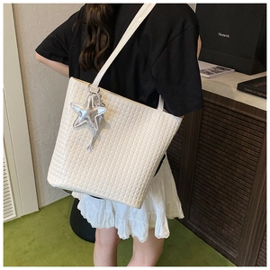 Detailed view of white woven texture tote bag with star charm and large capacity design