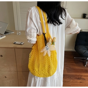 Detailed knit mesh of yellow tote bag featuring a white 3D floral accent with text
