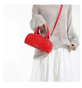 Détail du sac Boston rouge texture litchi avec ferrures argentées et texte stylé