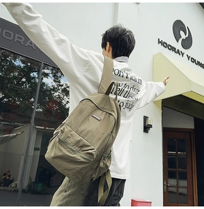 Close-up of army green canvas backpack featuring large capacity and front zipper pocket