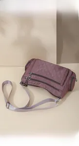 Close-up of quilted nylon crossbody bag featuring multiple zipper pockets and functional storage