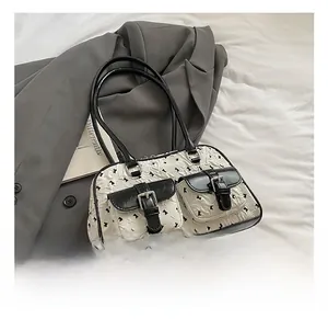Detail of white wrinkled shoulder bag with black butterfly prints and double pockets