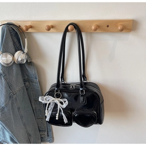 Close-up of black bowling shoulder bag with heart pockets and pearl lace charms