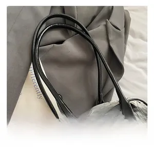 Detail shot of the contrast bow-patterned fabric surface and slim black leather handles
