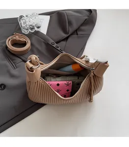 Close-up showing the large capacity of this beige pleated dumpling bag with daily essentials