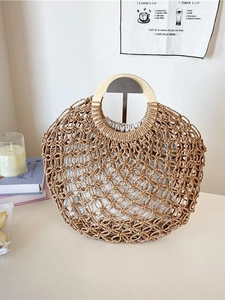 Handwoven straw tote bag with round wooden handles and drawstring cotton liner bag
