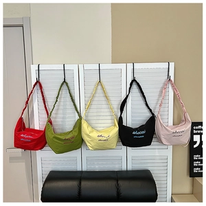 Detail of hobo bags with pleated scrunchie straps in five vibrant colors displayed indoors