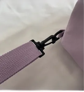 Detail of durable black rotating hook and purple nylon braided strap of the canvas bag