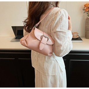 Side view of a pink shoulder bag featuring a silver heart buckle and pleated details