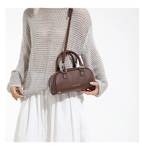 Vue rapprochée du cuir grainé litchi marron foncé sur ce sac bowling élégant