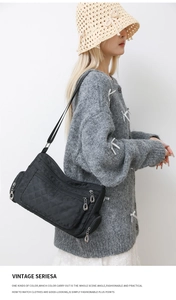 Detail of black nylon quilted crossbody bag with multiple metal zipper compartments