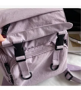 Detail view of purple nylon fabric texture and black plastic buckle on the backpack
