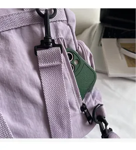 Detail of purple nylon bag featuring a matte black metal hook and hidden side zipper pocket