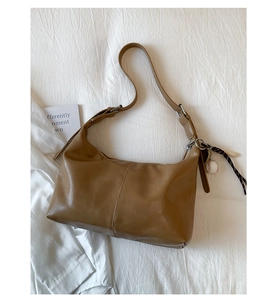 Detailed shot of brown faux leather hobo bag with adjustable strap and baseball charm
