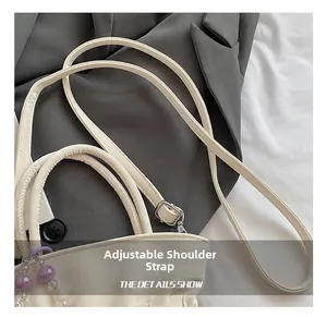 Detail showing adjustable leather shoulder strap and metallic buckle on bucket bag